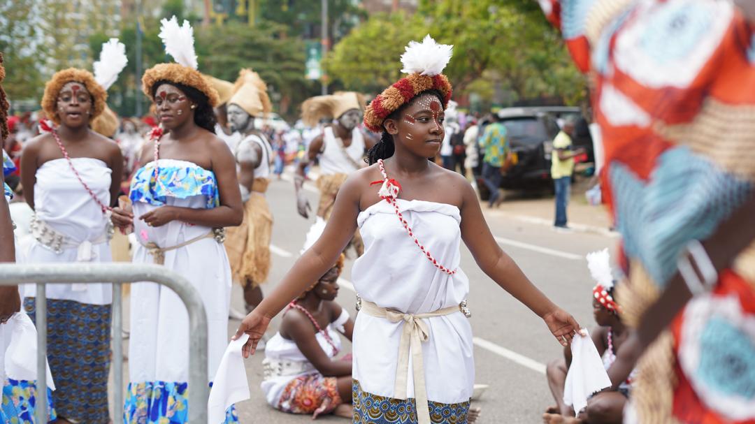 Des participantes en costumes blancs défilent à Libreville.