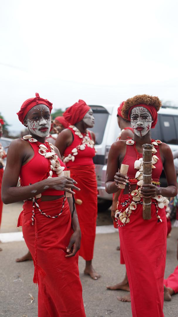 Un groupe en costumes rouges et parures blanches pendant la parade.